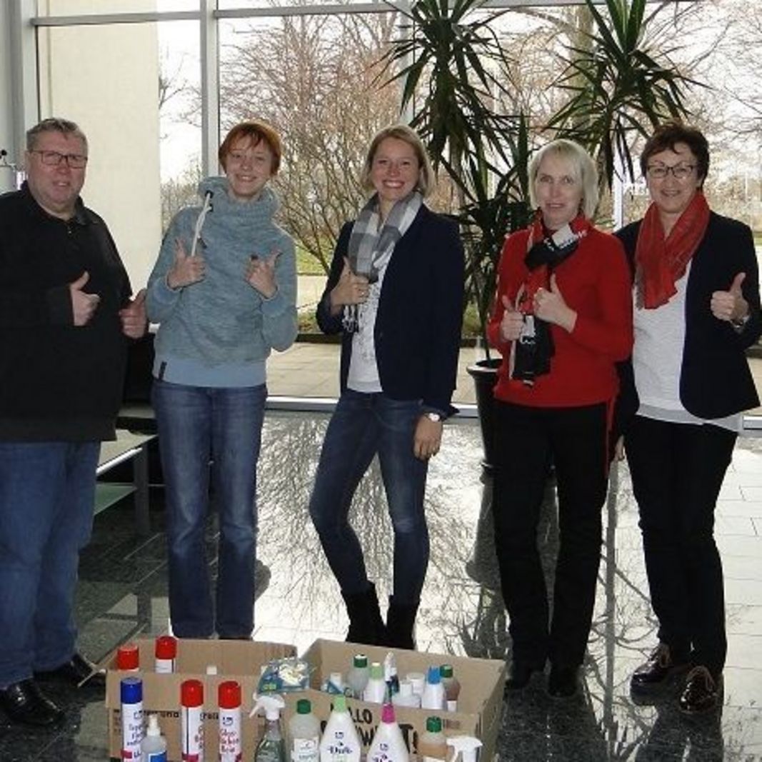 Vier Mitarbeiter*innen des Unternehmens Deutsche R+S Dienstleistungen Zeitarbeit GmbH zeigen anlässlich ihrer Spende dringend benötigter Reinigungsmittel an den Verein Märchenkoffer e.V. gemeinsam mit der Vereinsvorsitzenden den Daumen hoch.